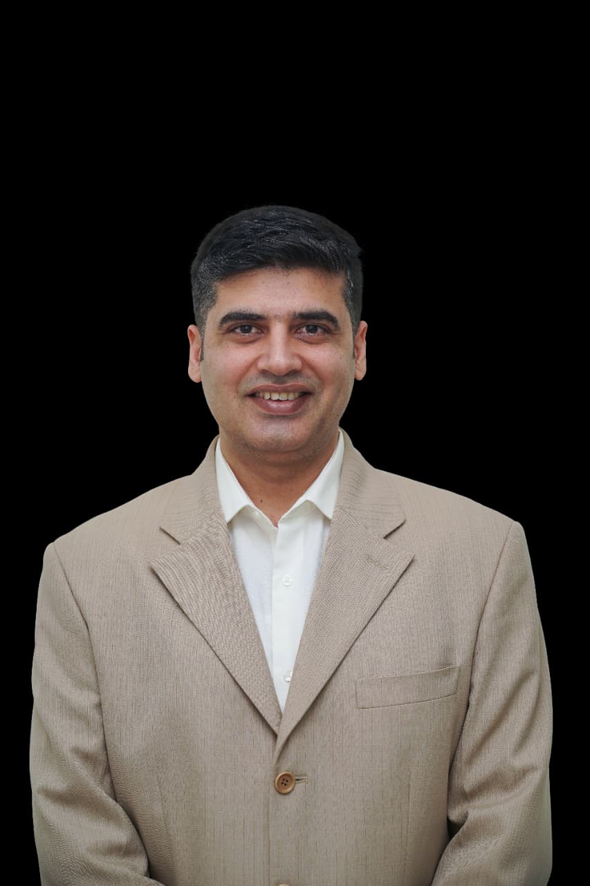 Portrait of Dr. Manpreet Singh in a beige jacket